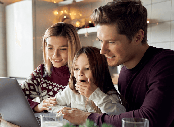 Family of three looking at a laptop screen, exploring products online