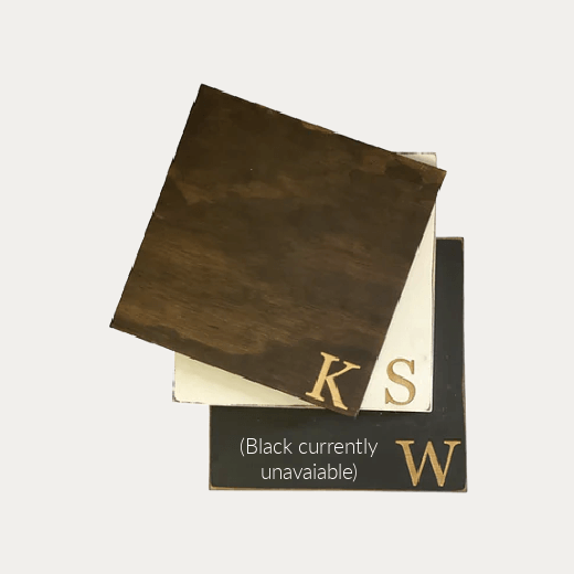 Monogram engraved square wooden lazy susan styled with linen napkins, salt and pepper shakers, and a jar candle on a round kitchen table — personalized lazy susan from The Red Hound Gifts
