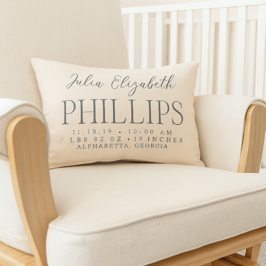 Personalized pillow with baby details on a beige chair