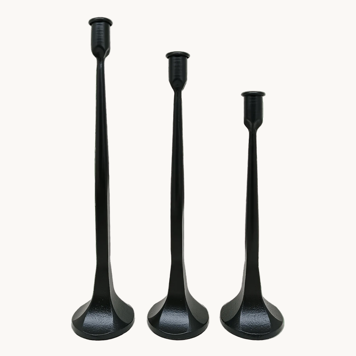 Set of 3 graduated black cast iron taper candle holders on a cream background — The Red Hound Gifts