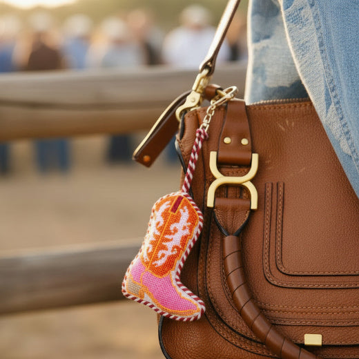 Needlepoint cowboy boot bag charm in pink and orange with red and white rope trim and gold tone clasp