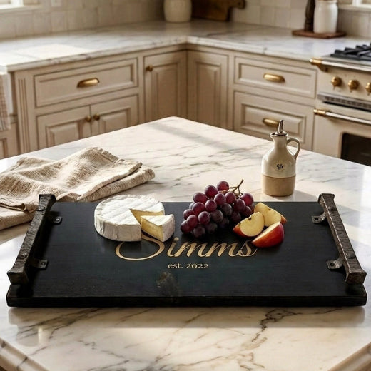 Personalized , engraved charcuterie tray styled on a marble kitchen island with cheese and grapes — custom engraved serving tray from The Red Hound Gifts

