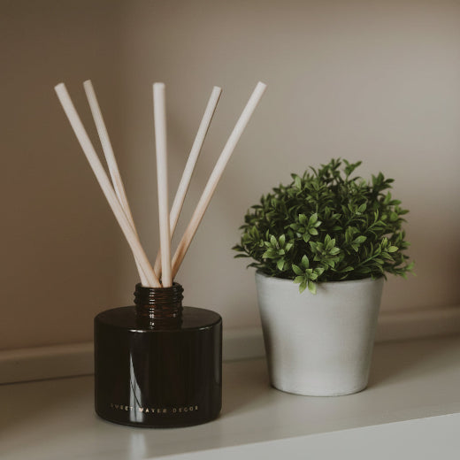 Farmhouse reed diffuser in amber glass jar with coordinating gift box and natural rattan reeds. The Red Hound Gifts.