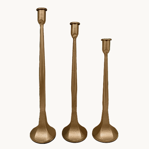 Set of 3 graduated gold cast iron taper candle holders on a cream background — The Red Hound Gifts