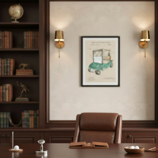 A framed vintage golf cart patent print featuring a watercolor-style illustration of a green golf cart with technical diagram markings, presented in a black frame against a light beige background.