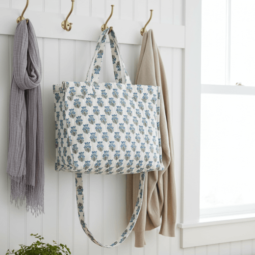 Blue Floral-patterned tote with a strap on a white background.