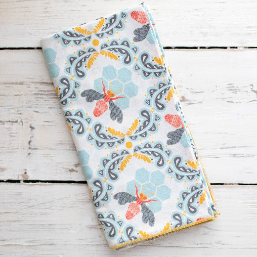 Honey bee and hive patterned cotton napkins in soft white, pale blue and terracotta colors.