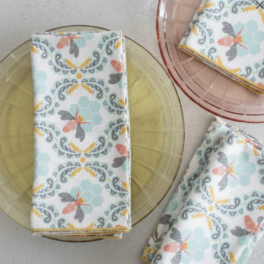 Honey bee and hive patterned cotton napkins in soft white, pale blue and terracotta colors.