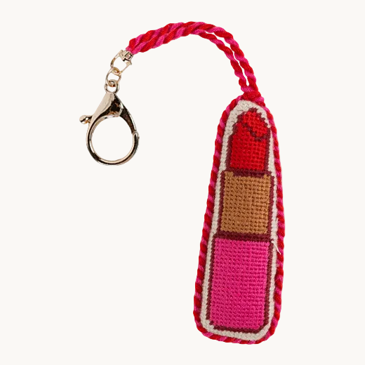 Lipstick needlepoint bag charm in hot pink with red braided edge and gold tone lobster clip — glam bag accessory from The Red Hound Gifts