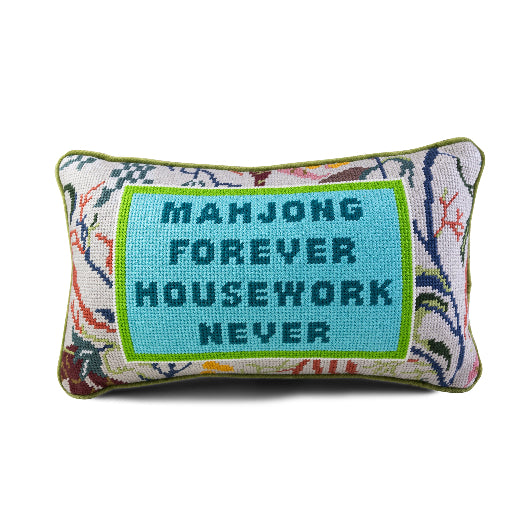 Decorative pillow with text on a beige armchair in a living room setting.