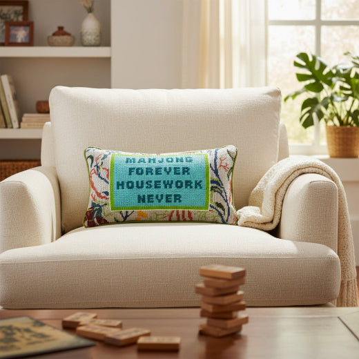 Decorative pillow with text on a beige armchair in a living room setting.