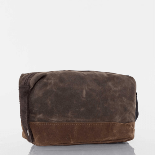 Brown waxed canvas toiletry bag on a white background