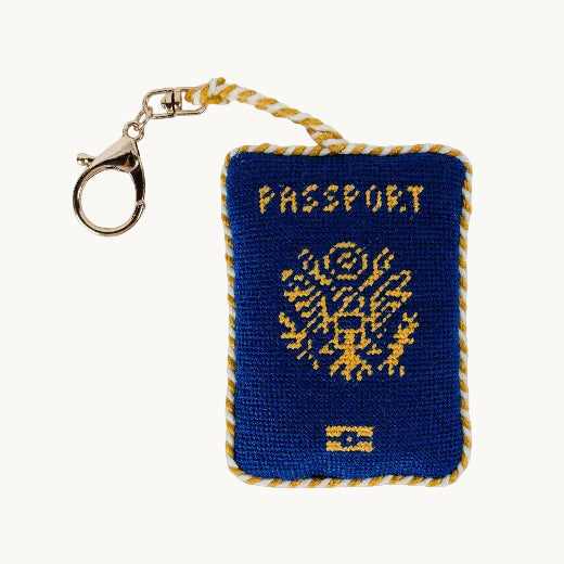 Needlepoint passport bag charm in navy blue with yellow and wihte cording on the border and gold tone chain lobster clasp 