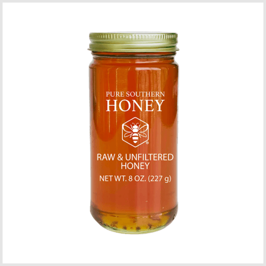 Jar of 8 oz. Honey with a gold lid on a solid background