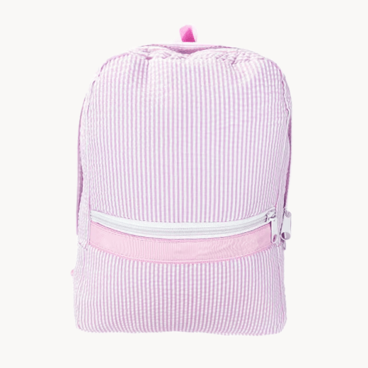 Pink striped backpack with 'Sophie' embroidered on it, placed on a wooden chair.