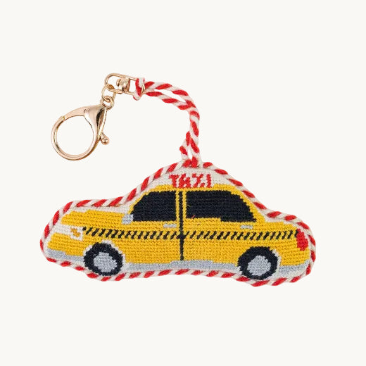 Taxi cab needlepoint bag charm with red and white rope trim and gold-tone lobster clasp on white background