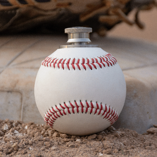 Baseball-shaped flask on a baseball field background