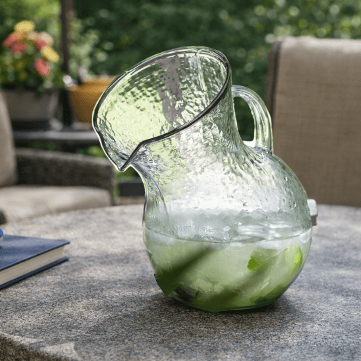 Clear glass pitcher with on a stone patio table