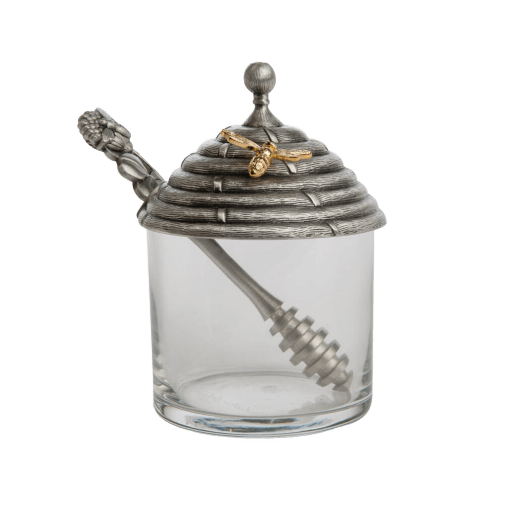 Glass honey pot jar with decorative lid featuring a bee and hive design includes a honey stirrer