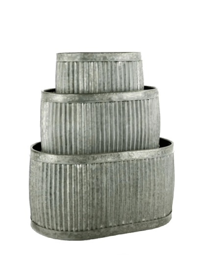 Decorative metal planters with plants and flowers on a stone patio next to stacked firewood.