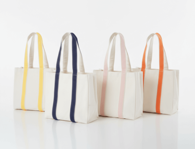 Four tote bags with colorful accent straps on a white background