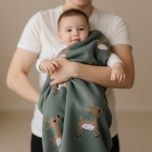 Woodland Deer baby blanket in Meadow Sage — soft luxury cotton knit with baby deer motif, folded flat