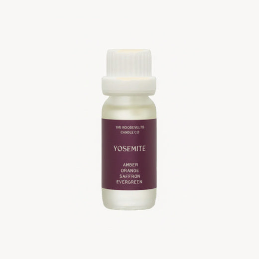 Small bottle of diffuser oil with a white cap and purple label on a white background