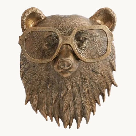 Antique brass finished bear bust wall mount with textured ruff and oversized spectacles.