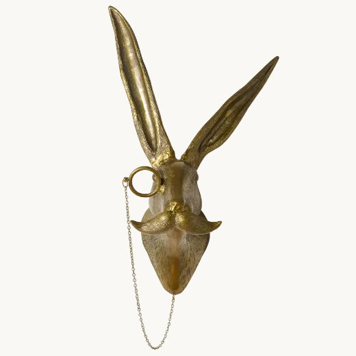Antique brass finish hare bust wall mount with curled mustache and monocle on a chain.
