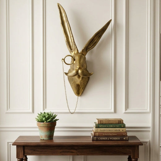 Antique brass finish hare bust wall mount with curled mustache and monocle on a chain.