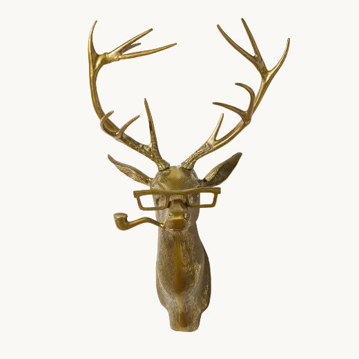 Antique brass finish buck head wall mount with antlers, squared spectacles, and a pipe.